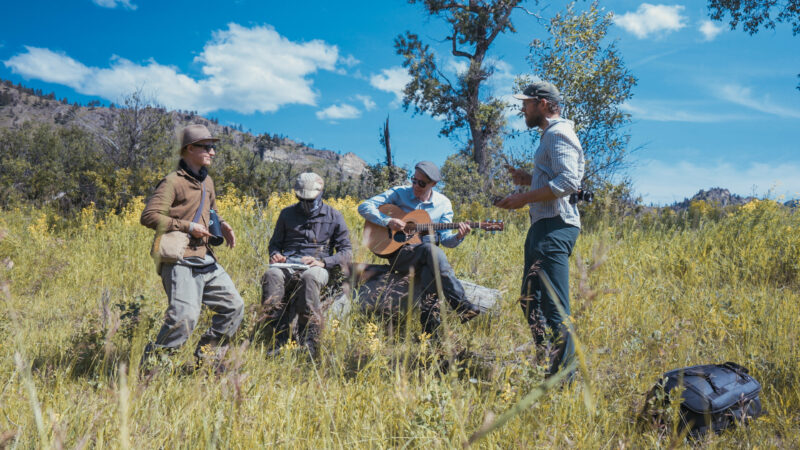 Jazz & Fly Fishing in een weiland, een van hen met gitaar