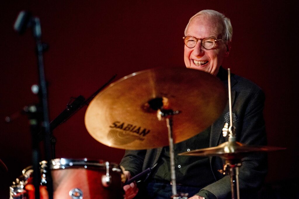 Drummer Eric Ineke lacht achter zijn drumstel.