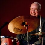 Drummer Eric Ineke lacht achter zijn drumstel.