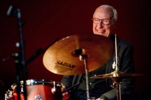 Drummer Eric Ineke lacht achter zijn drumstel.