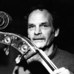 Zwart-witportret van contrabassist Kent Carter in 1998, met de krul van zijn contrabas naast zijn gezicht